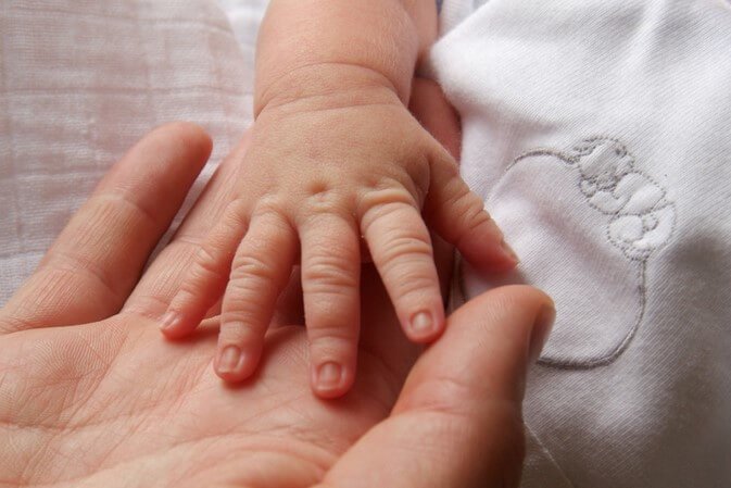 Babyhånd i en voksens hånd