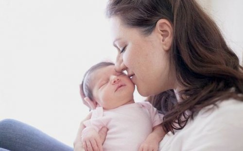 Mot som holder nyfødt baby