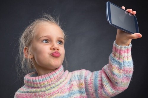 barn holder mobiltelefon ta selfie