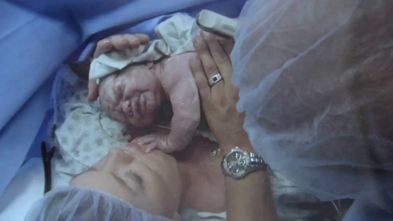 Mor holder nyfødt baby på sykehus