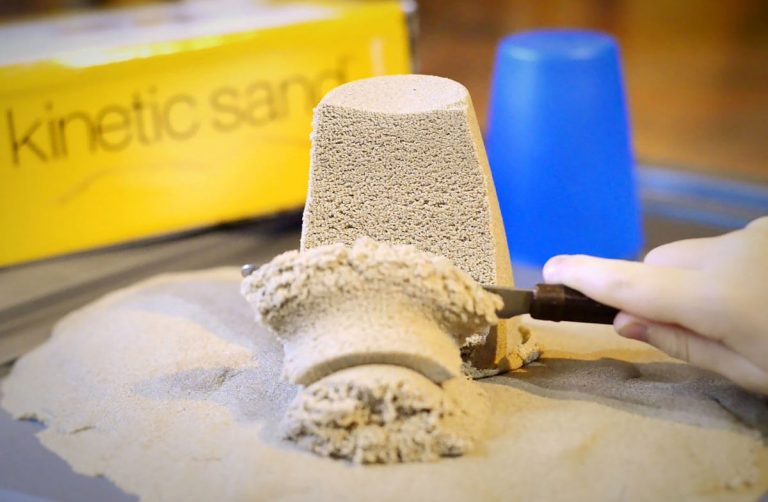 La barna dine grave med sine hender i magisk sand!