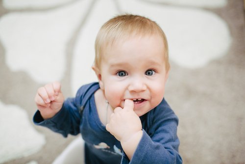 Et barn med en finger i munnen.