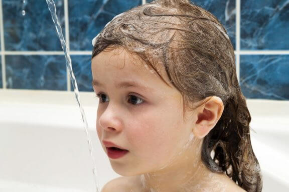 En jente som bader i et badekar.