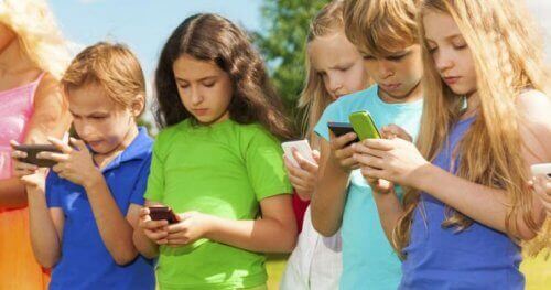 Barn som er opptatt med mobiltelefonene sine