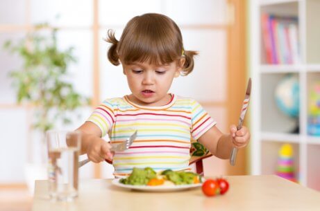 En ung jente spiser salat.