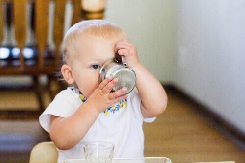 Baby drikker av kopp