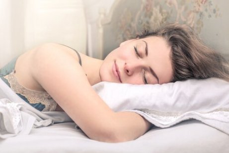En kvinne sover godt i sengen sin