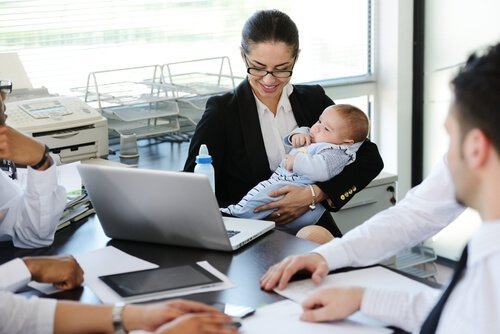 En kvinne som har tatt med babyen på arbeidet.