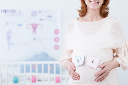 En eldre gravid kvinne med "40+" på magen.