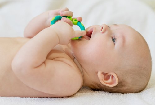 En baby som tygger på en leke.