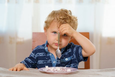 Gutt spiser med venstrehånd