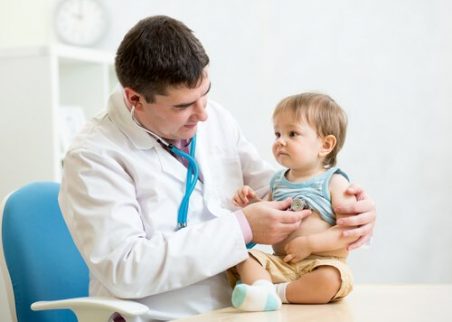 En lege sitter med et barn.