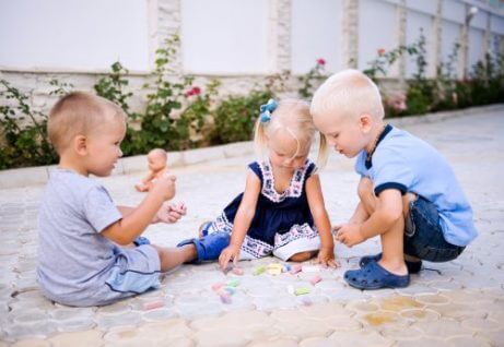 En jente og to gutter leker sammen.