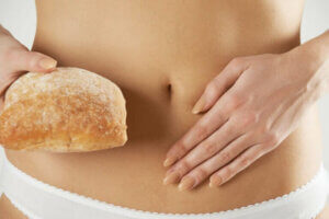 En kvinne som holder et brød ved siden av magen sin