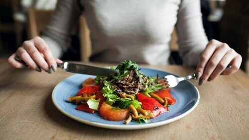 Kvinne som spiser en su nn rett på restaurant.