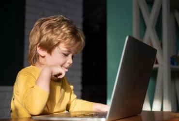 En gutt som bruker en bærbar datamaskin
