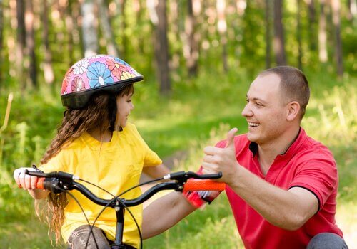 En pappa som lærer barnet sitt å sykle