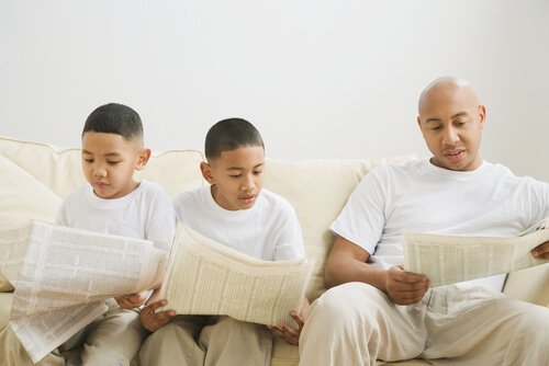 Barn og voksen leser avis