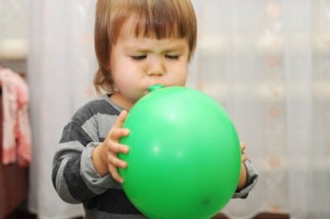 barn blåser opp ballong