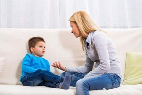 En mor som snakker med barnet sitt i sofaen