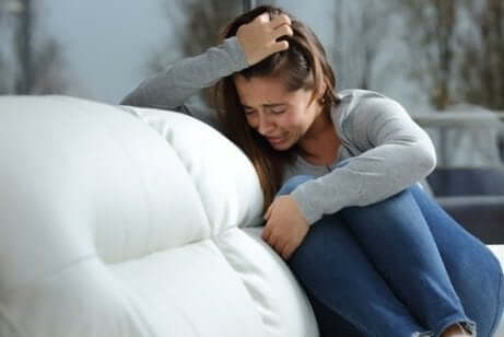 En tenåringsjente som gråter i en sofa