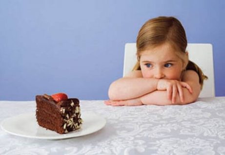 Et lite barn som ser på et kakestykke