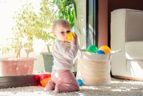Baby leker med baller i en kurv