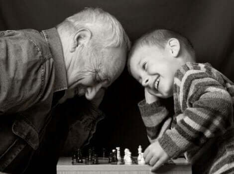 En gammel mann som spiller sjakk med et barn