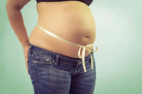 En gravid kvinne med en sløyfe knyttet rundt magen.