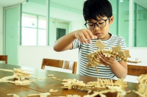Et barn som bygger en dinosaurus