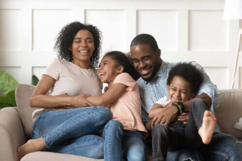 En familie som sitter i en sofa og ler sammen
