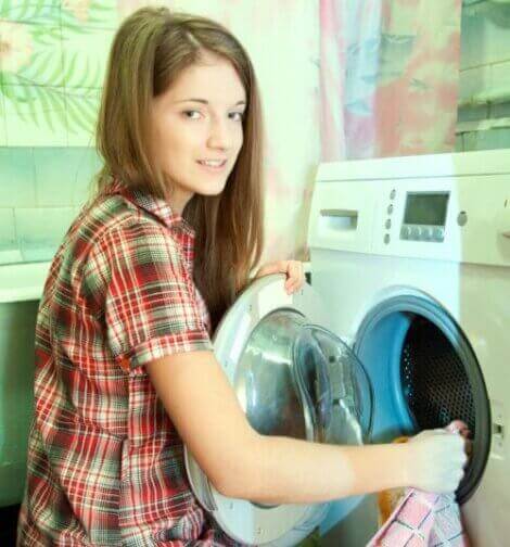 En ungdom som setter på en vaskemaskin