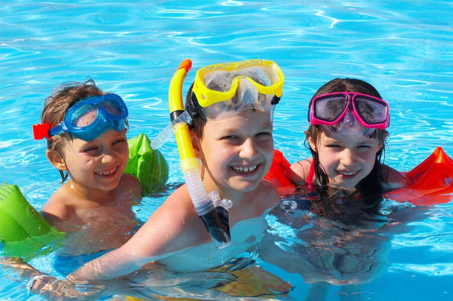 Barn som leker i et basseng med snorkelutstyr