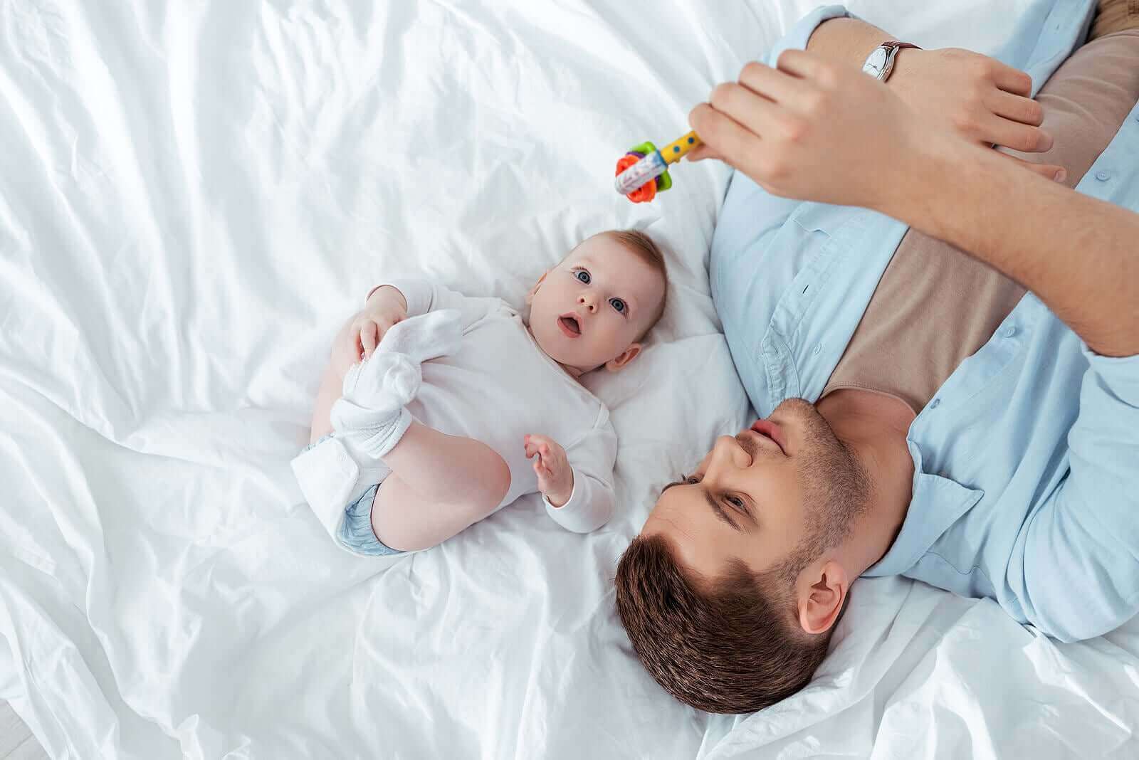 En far og baby som leker med en rangle