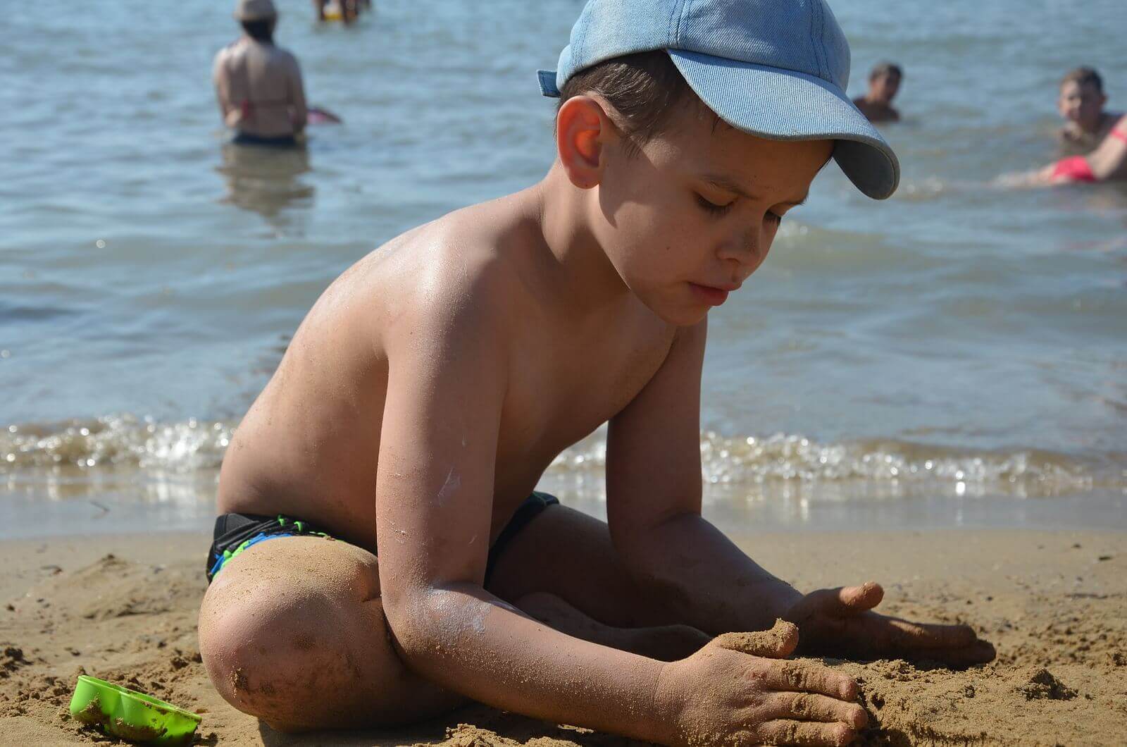Et barn som leker i sanden på stranden