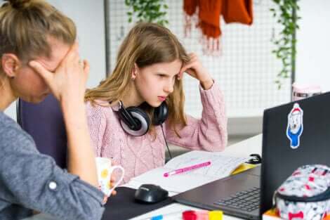 En mor som sitter og prøver å hjelpe tenåringen sin med lekser