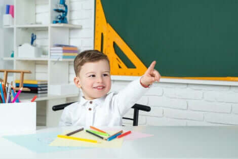 Et barn som rekker opp hånda på skolen.