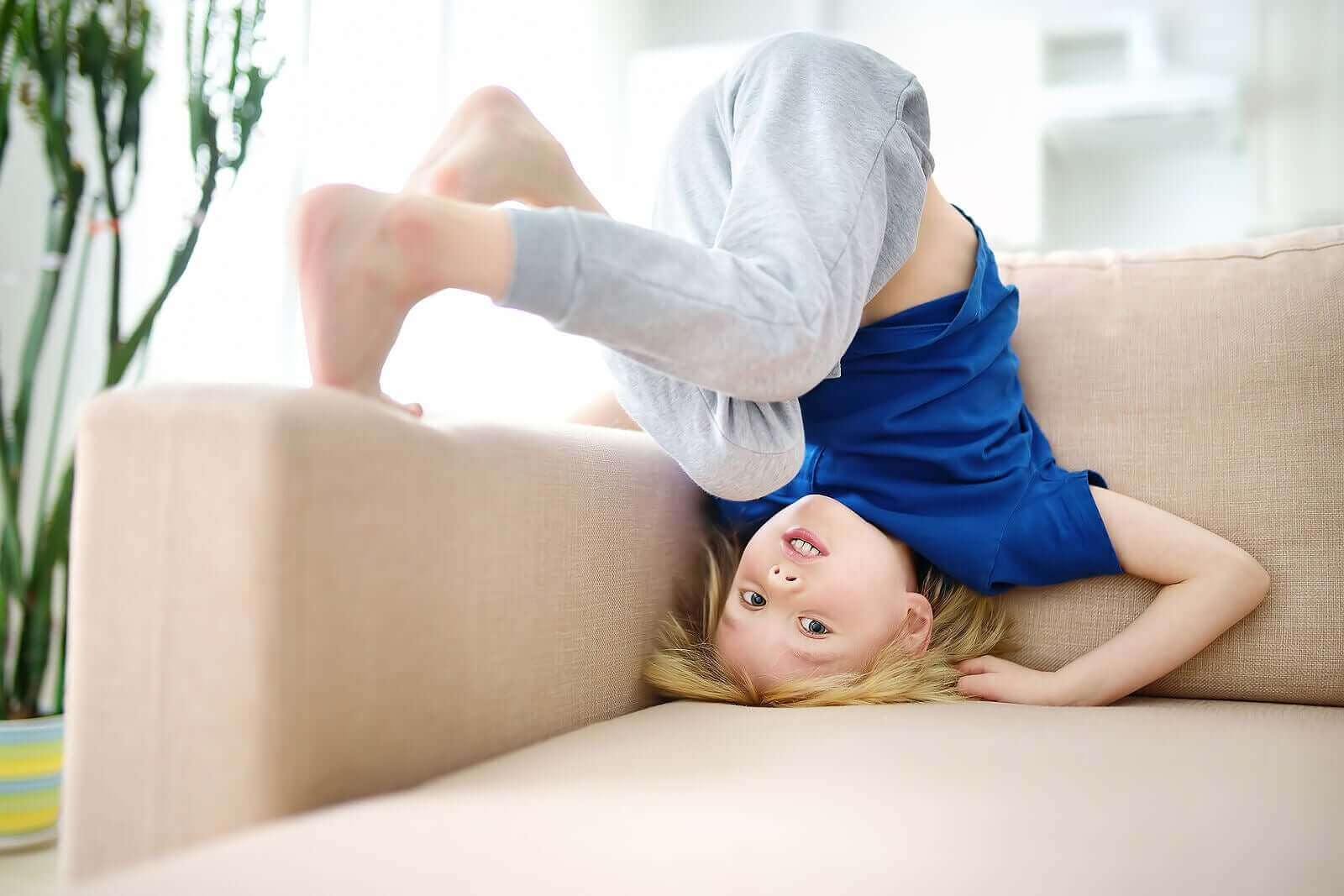 Et barn som stuper kråke i en sofa