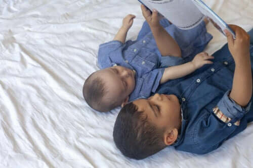 et søskenpar som leser bok i sengen