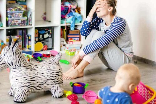 En mor som sitter med barnet sitt på lekerommet